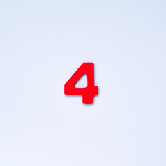 Wooden number 4 with red color on white background.