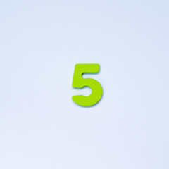 Wooden number 5 with green color on white background.