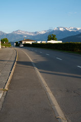Road in weggis, switzerland leading to a view of the alps in the background