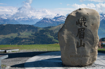 Boulder taken from Mt Emei at the top of its sister mountain of rigi with mountains in the background