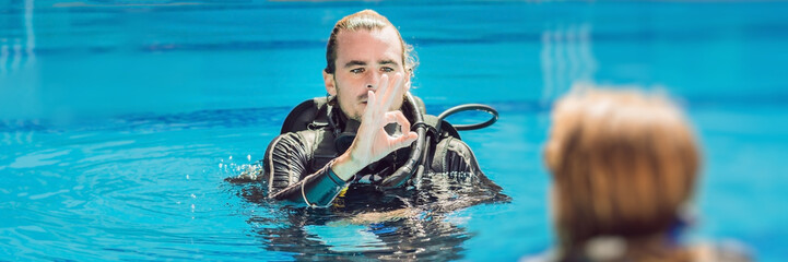 Diving instructor and students. Instructor teaches students to dive BANNER, long format
