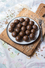 Raw vegan sweet balls with dates, coconut, cocoa powder, cocoa butter, banana and nuts. Vegetarian truffel dessert with carob powder.