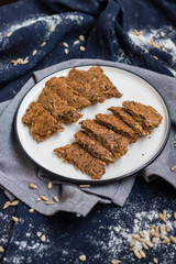 Woman hands holds dark rye bread slices. Homemade dark bread with coriander seeds on plate. Vegan vegetarian healthy food. Bread made of whole grains on dry frying pan. 