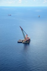 Derrick Lay Barge is laying pipeline at offshore with pipe haul barge moored alongside.