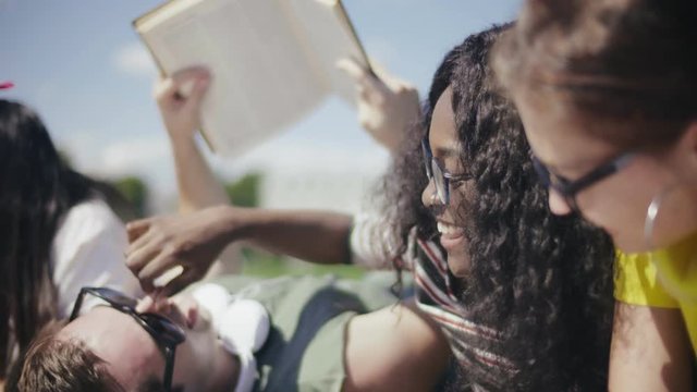African girl tweaking caucasian boy's nose and laughing