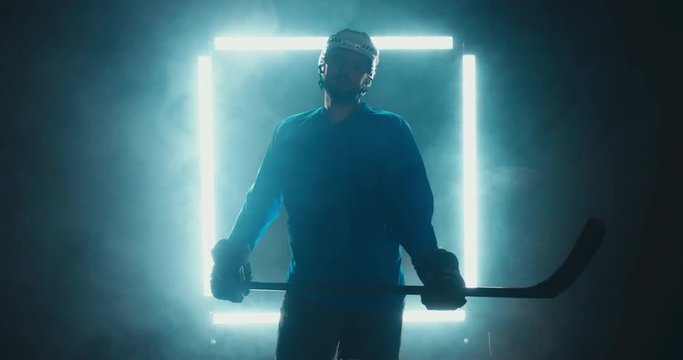 FIXED Portrait of Caucasian male ice hockey player in uniform, looking into the camera, dramatic lighting. 4K UHD 60 FPS SLOW MOTION