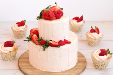 Big cake and cupcakes with strawberries and raspberries. Cake for wedding, birthday.