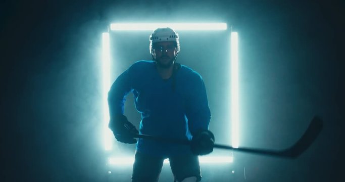 FIXED Portrait of Caucasian male ice hockey player in uniform, looking into the camera, dramatic lighting. 4K UHD 60 FPS SLOW MOTION