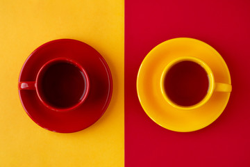 Tea in cups on different backgrounds. Yellow and red cups of tea pairs on yellow and red...