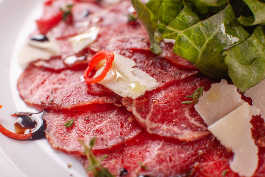 Carpaccio , beef steak salad. Summer launch, healthy eating concept. white plate with sauce. salad served in italian style
