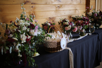 Fototapeta na wymiar Wedding Reception Table with Wedding Favors, Floral Arrangements, Bride and Bridesmaids Bouquets