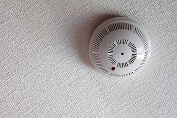 white fire alarm sensor on the ceiling