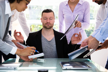 Young Businessman Meditating In Office