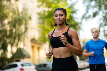 Young man and woman running outdoors