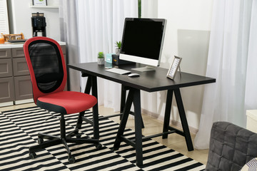 Comfortable workplace with monitor in interior of beautiful modern room