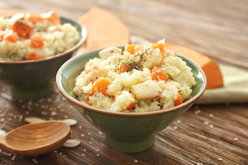 Bowl with delicious pumpkin risotto on wooden table