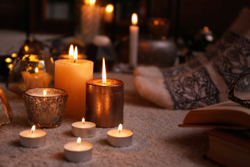 Burning candles on floor indoors