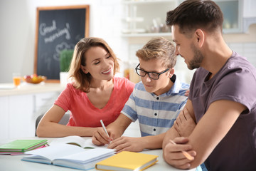 Teenager with parents doing homework at home