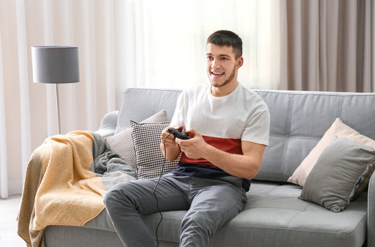 Emotional man playing video game at home