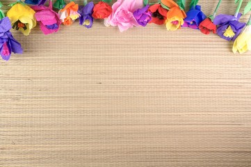 Beautiful origami flowers / paper flowers on a woven texture with copy-space