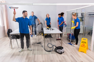 Group Of Skilled Janitors Cleaning Office