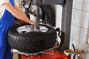 Mechanic changing car tire in service center