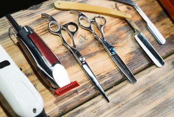 Scissors and other tools for barber on wooden table closeup