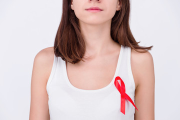 Safe sex / healthcare concept. Girl woman female wearing white top with pinned red ribbon as a...