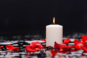 Still life with red rose petals with candle and therapy stones 