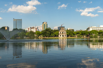 Hoan Kiem lake or Sword lake, Ho Guom in Hanoi, Vietnam with Turtle Tower, on clear day with blue sky and white clouds