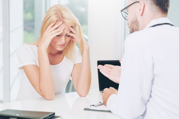 Male Doctor and Female Patient in Hospital Office