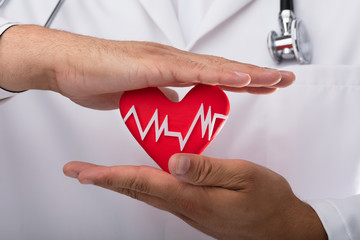 Doctor holding red heart rate