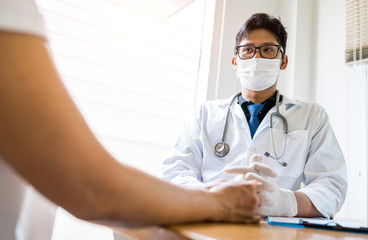 A doctor is working in the hospital, he is wearing a brown stethoscope and he is investigating the illness of the patient.