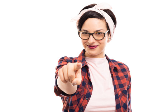 Young pretty pin-up girl wearing glasses pointing finger.