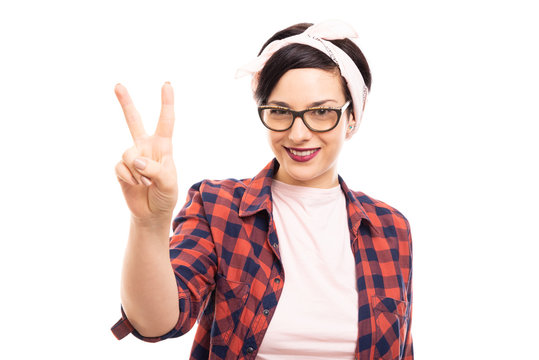 Young pretty pin-up girl wearing glasses showing victory gesture.