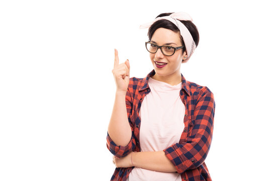 Young pretty pin-up girl wearing glasses making idea gesture.