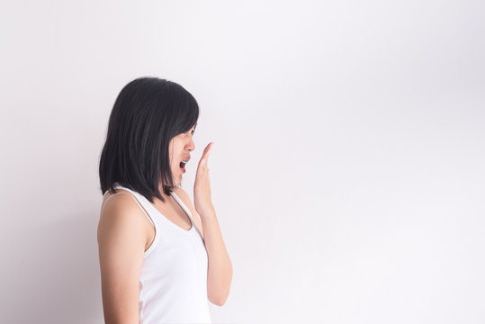 Asian woman covering her mouth and smell her breath with hands after wake up,Bad smell