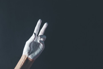 White painted hand on a black background. Abstract. Copy space