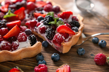 Delicious pie with ripe berries and piece on shovel, closeup