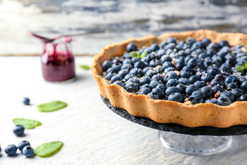 Dessert stand with delicious blueberry pie on table