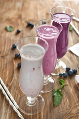 Glasses of tasty blueberry smoothie on wooden table