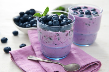 Glasses of tasty blueberry smoothie on table