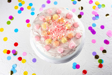 Stand with tasty birthday cake and burning candles on white table