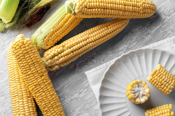 Composition with fresh corn cobs on table