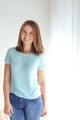 Portrait of beautiful young woman near window