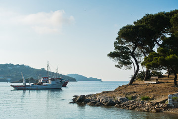 Ships anchored in front of small island and Skiathos town, Skitahos island, Greece