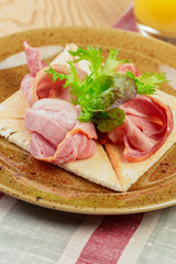 Russian pancake with ham slices close up