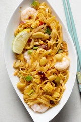 Pad thai noodles with prawns, mixed greens, chopped peanuts, shallots & lime wedge
