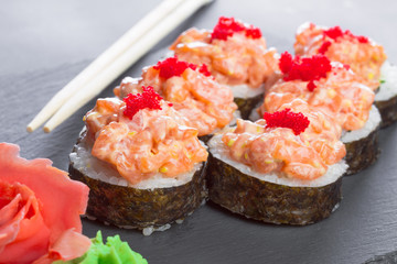 Japanese restaurant, sushi roll on black slate plate.