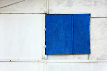 Obraz na płótnie Canvas Blue Shutter on a Wooden Exterior Wall